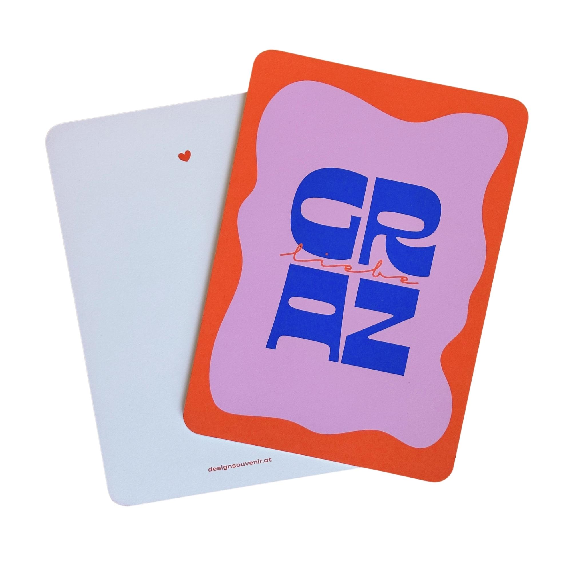 Bild zeigt Vorder- & Rückseite von Kartenmotiv mit Schriftzug "Graz Liebe" auf weißem Hintergrund.